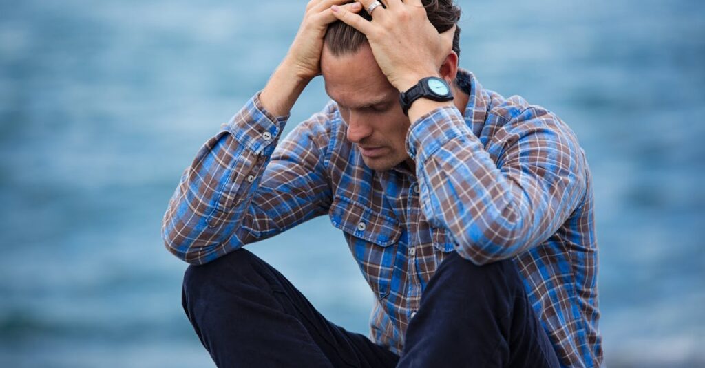 best seo hacks for 2025 A man in a plaid shirt sits by the water looking distressed, symbolizing stress.